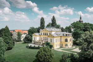 une vue aérienne sur une grande maison sur une pelouse dans l'établissement Zámek Dobřenice, 