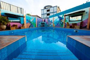 a swimming pool with a mural on the side of a building at Bays Lodge, Accra in Accra