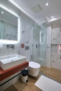 y baño con aseo, lavabo y ducha. en ADORA's VIEW HOTEL, en Sarandë