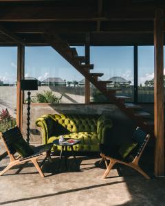 um sofá verde e duas cadeiras num pátio em DABA - Designer Villas in Perenenan - Beach 600M em Canggu