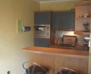 a kitchen with a counter and some chairs in it at Ferienwohnung am Gespensterwald in Nienhagen