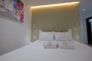 a bedroom with a large white bed with white pillows at ADORA's VIEW HOTEL in Sarandë