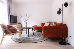 een woonkamer met een bank en een tafel bij Luxe Vakantiehuis Koekoek Veluwe in Nunspeet