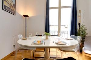 une salle à manger blanche avec une table et des chaises blanches dans l'établissement *Appart 2 chambres, Hypercentre, Emplacement N°1*, à Montpellier
