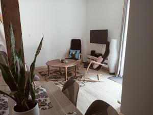a living room with a table and a tv at Le hangar de mamie in La Charrière