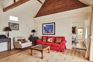 a living room with a red couch and a table at The Clock Tower & The Dairy - Two x 2 Bed Barns with Indoor Pool in Checkendon