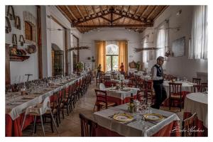 een man in een grote kamer met tafels bij Fattoria Manostalla Villa Chiarelli in Balestrate