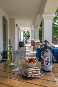 uma mesa com um prato de bolachas e uma garrafa de vinho em Oszter Udvarház em Kékkút