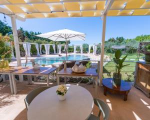 a patio with tables and chairs and a pool at Relais San Baio in Cecina