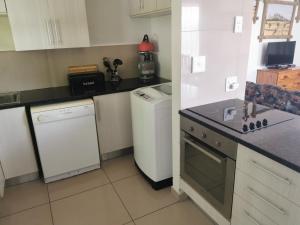 uma cozinha com um frigorífico branco e uma máquina de lavar louça em Cycadales Villa em Sabie