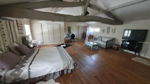 ein Schlafzimmer mit einem großen Bett und ein Wohnzimmer in der Unterkunft Chez Martine in Hanc