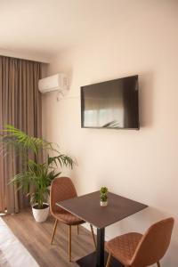 a dining room with a table and chairs and a tv at Wave Beachfront Apartments in Durrës