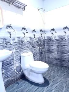 baño con aseo y lavabo y aves en la pared en Kaveri Palace, en Mysore