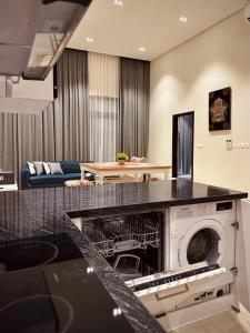 a kitchen with a dishwasher in a living room at Hawana Lagoon Private villa with private pool in Salalah