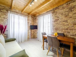 a living room with a wooden table and a brick wall at Nymfes Corfu Apartments in Corfu Town