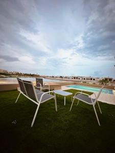 a group of chairs and a table and a swimming pool at Hawana Lagoon Private villa with private pool in Salalah