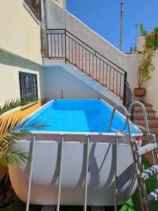 een zwembad in de achtertuin van een huis met een trap bij Bonita casa en Granada+PARKING EN EL CENTRO+WIFI in Ambroz