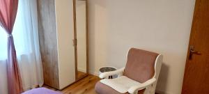 una silla sentada en una habitación con espejo en Carmen apartman en Brčko