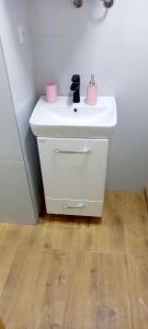 baño con lavabo blanco y 2 macetas rosas en Carmen apartman en Brčko