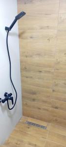 un cabezal de ducha en una pared junto a un suelo de madera en Carmen apartman en Brčko