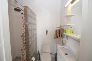 a white bathroom with a toilet and a sink at Balliwood værelsesudlejning in Ballen