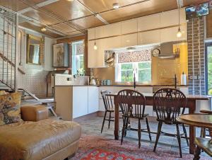 a kitchen and dining room with a table and chairs at Moorhen Lodge in Wickham