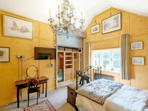a bedroom with a bed and a chandelier at Moorhen Lodge in Wickham