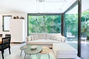 sala de estar con sofá y mesa en Tranquil 2BR GardenOasis near the Sea by HolyGuest, en Tel Aviv