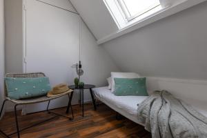 een witte kamer met een bed en een raam bij Peulenstraat 224 in Hardinxveld-Giessendam