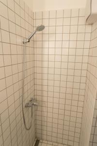 een douche in een wit betegelde badkamer bij Peaceful Basement Apartment with Terrace & free GYM in Boedapest