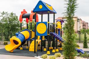 a playground with a slide in a park at хотел ADDRESS in Ravda