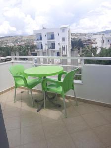 a green table and chairs on a balcony at Villa Shehu in Ksamil