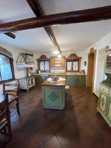 een grote keuken met groene kasten en een tafel bij Casa incantevole di Montagna con vista mozzafiato in Roana