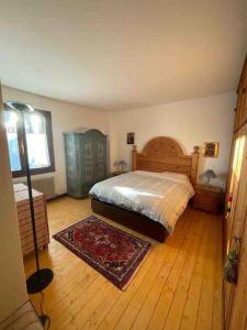 a bedroom with a bed and a wooden floor at Casa incantevole di Montagna con vista mozzafiato in Roana