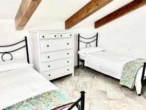 Cisano sul NevaにあるVilla Marco Aurelioのベッドルーム1室(ベッド2台、ドレッサー付)