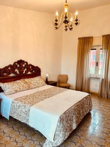 ein Schlafzimmer mit einem großen Bett und einem Kronleuchter in der Unterkunft Casa nostra in Cisterna dʼAsti
