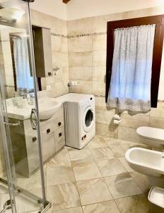 a bathroom with a washing machine in the corner at Villa Marco Aurelio in Cisano sul Neva