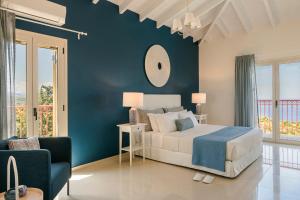 フィスカルドにあるVilla Alkyoniの青い壁のベッドルーム1室(ベッド1台付)