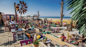 a group of people sitting in chairs at a beach at The East Wing Bloemendaal in Bloemendaal