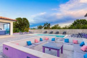 a patio with a pool and a table and chairs at Villa 9 in Marčana