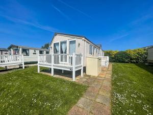 a house with a porch and a yard at Lovely 8 Berth Caravan At Hopton Holiday Park To Hire In Norfolk Ref 80017l in Great Yarmouth