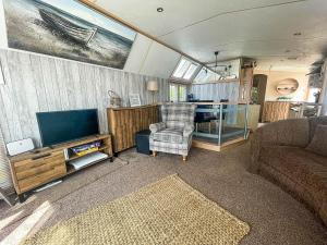 a living room with a couch and a tv at Lovely 8 Berth Caravan At Hopton Holiday Park To Hire In Norfolk Ref 80017l in Great Yarmouth
