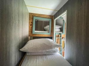 a bedroom with a bed with a mirror on the wall at Lovely 8 Berth Caravan At Hopton Holiday Park To Hire In Norfolk Ref 80017l in Great Yarmouth
