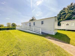 a mobile home in a yard with a large grass field at Beautiful 6 Berth Caravan With Decking In Norfolk Ref 89001mv in Belton