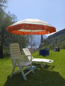 due sedie e un ombrellone sull'erba di L'angolo di pace e relax del lago di Garda a Riva del Garda