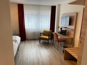 une chambre d'hôtel avec un bureau et un lit dans l'établissement Art Hotel Eifel, à Heimbach