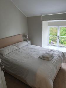 a bedroom with a large white bed with a window at The Ship Inn in Truro