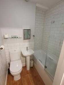 a bathroom with a toilet and a sink and a tub at The Ship Inn in Truro