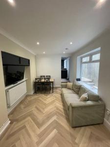 a large living room with a couch and a television at The Mount in Swansea