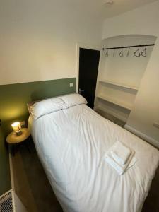 a small bedroom with a bed with a towel on it at The Mount in Swansea